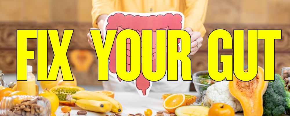 Person holding a cartoon image of a large intestine behind a table full of fresh fruits, vegetables, and healthy foods with bold yellow text that says "Fix Your Gut"